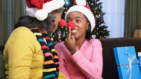 A mother and daughter show off their red Rudolph the reindeer noses.