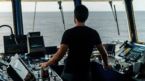An image of a ship captain navigating their boat.