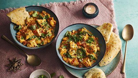 Turkey curry in bowls with naan
