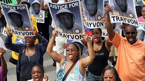 A group of African American people marching with posters that say 'justice for Trayvon'