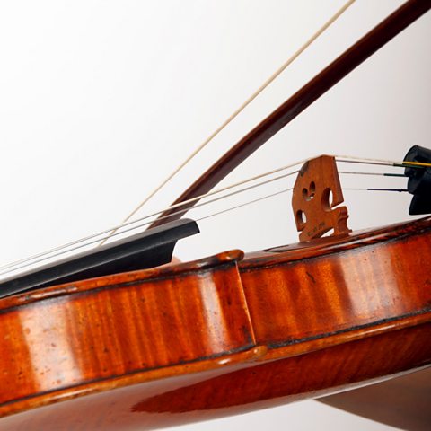 A violin is played using the wooden back of the bow