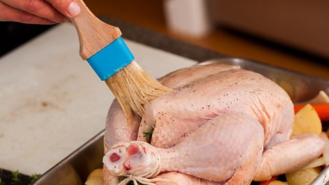 Is basting necessary? A chicken is basted with a brush before going into the oven