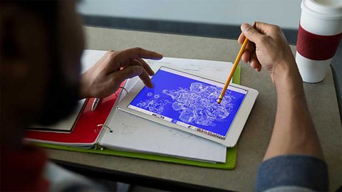 A pair of hands drawing a blueprint on a tablet