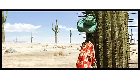 A cartoon lizard in the desert in a Hawaiian shirt, his back against a cactus