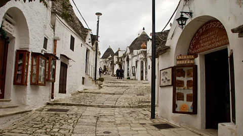 Victoria Abbott Riccardi The cobbled walkways in Alberobello are lined with trulli, including this one selling paintings on local olive wood (Credit: Victoria Abbott Riccardi)