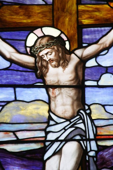 A stained glass image of Jesus on the cross.