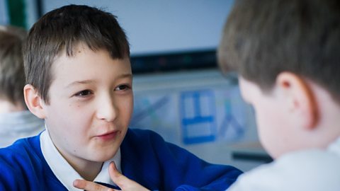 Two school children talking.