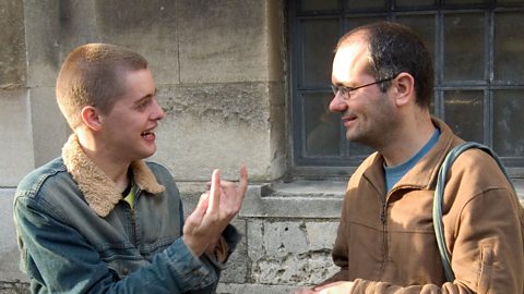 Two men communicating in sign language.