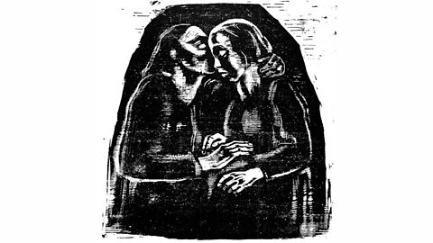 A seated couple in black and white. One is kissing the other