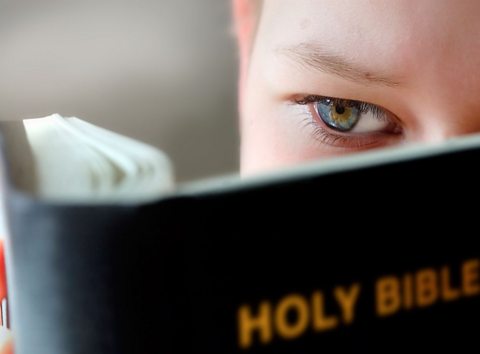 A child reading the Christian Bible.