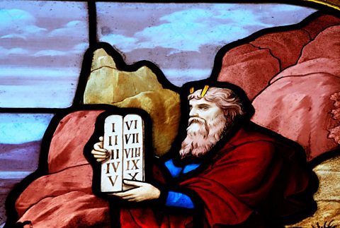 A stained glass depiction of Moses and the Ten Commandments.