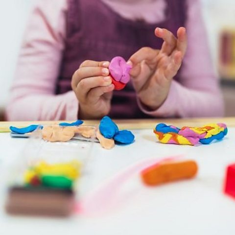 A child moulding some pink and red clay. 