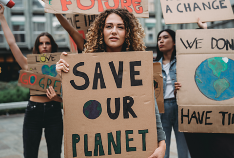 Climate protesters holding signs saying save the planet.