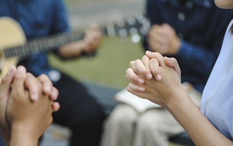 People praying and holding their hands together. 