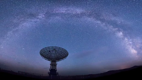 Honglouwawa/Getty Images Arc of stars above radio dish antennae (Credit: Honglouwawa/Getty Images)