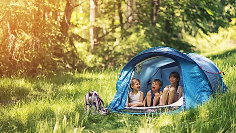 Hiker kids sitting in tent in the forest