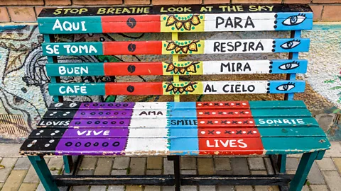 Getty Images A bench in Bogota, Colombia, with Spanish and English messages inviting ers-by to take a coffee break (Credit: Getty Images)