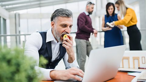 person eating an apple in an office