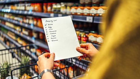 Woman with shopping list in grocery store