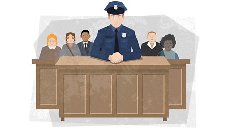 Officer Moore sat behind a large desk in court. There are people sat behind him, including Jerome's ghost.