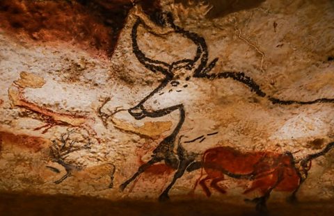 A cave drawing of an animal with horns.