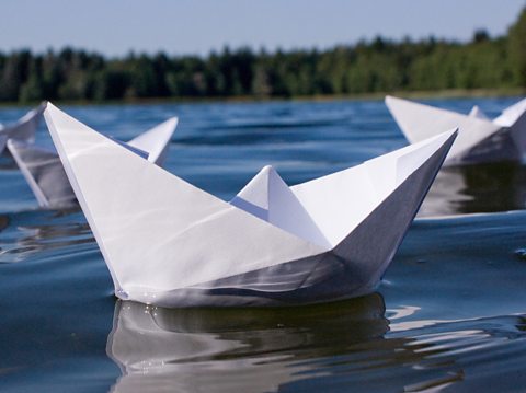 Paper boats floating on a lake.