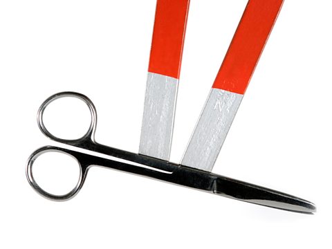 A pair of scissors magnetically attached to a horseshoe magnet.