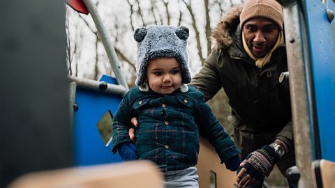 A dad and his toddler son at the park.