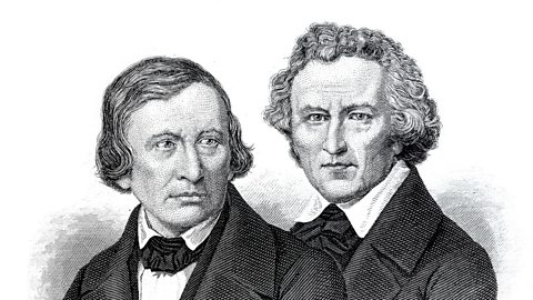 An illustration of Jacob and Wilhelm Grimm, two white older men in suits.