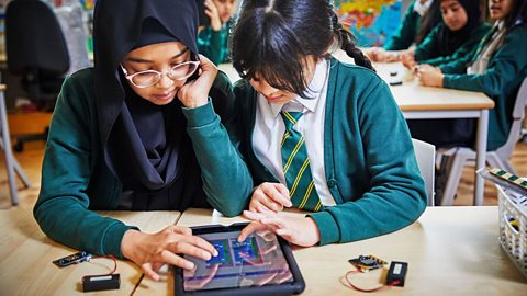 Two primary school children create code for the micro:bit using a tablet