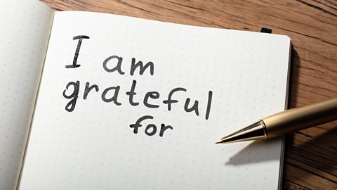 Close up of the words 'I am grateful for' written in a notebook