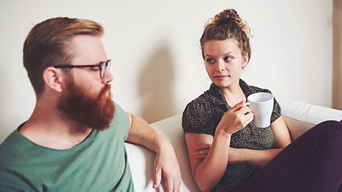 Two parents have a serious conversation on the sofa