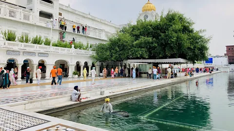 Raphael Reichel Sikhs all over the world do seva, such as cleaning the Golden Temple's holy pool (Credit: Raphael Reichel)