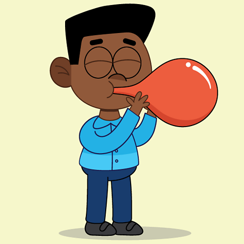 A boy blowing up a balloon to show how your tummy can fill with air when you take a deep breath.