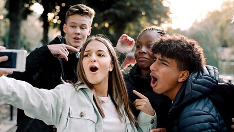 Young teenagers filming a selfie video on the side of the road