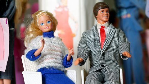 Barbie and Ken in plastic chairs.