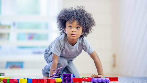 A little boy playing with building blocks