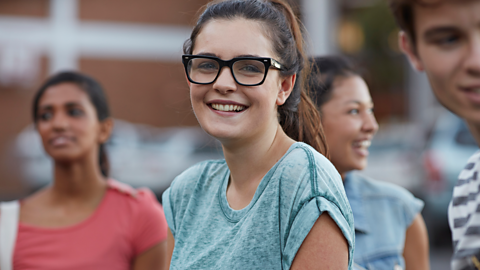 Student smiling at camera in a group of students