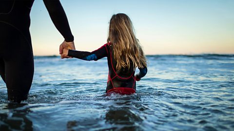 A girl wading through water.