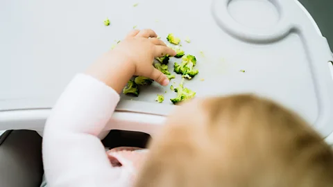 Getty Images A baby with broccoli pieces in front of them (Credit: Getty Images)