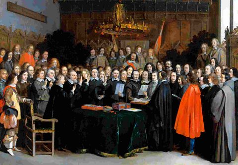 Formal portrait of officials in 17th Century dress crowded round a table of documents.