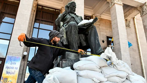 Getty Images A museum worker takes measures to protect a statue in Zaporizhzhia – monuments such as these  are at risk of damage (Credit: Getty Images)