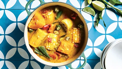 Christine Han A bowl of ital stew on a table next to a quartered lime