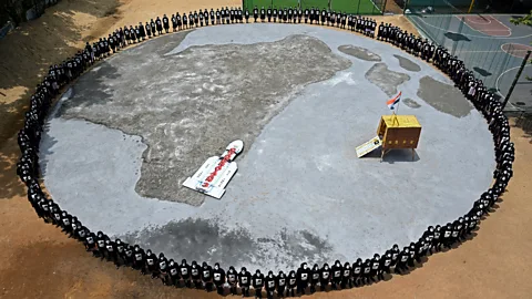 Getty Images School children wearing face paint form a ring around a model of the Vikram lander (Credit: Getty Images)