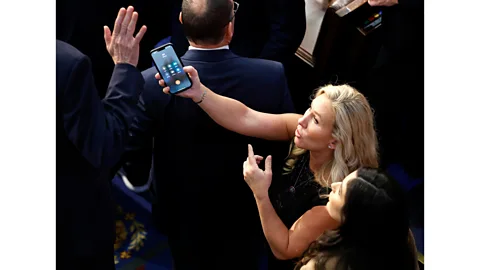 Getty Images Marjorie Taylor Greene holds up a phone with Donald Trump on hold (Credit: Getty Images)
