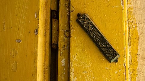 Mezuzah on a yellow door frame.