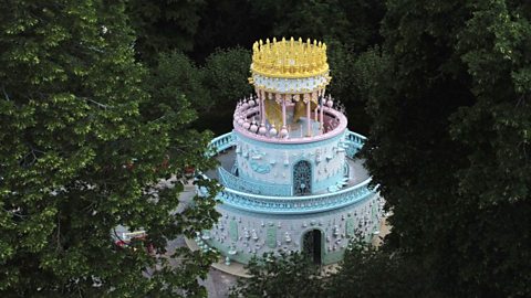 A giant 3-tiered wedding cake structure in a country park.