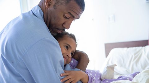 Worried dad hugs oblivious child