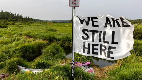 Getty Images Indigenous tribal members fly a flag in Minnesota in 2021, during a fight to stop a pipeline expansion to bring in tar sands from Canada (Credit: Getty Images)