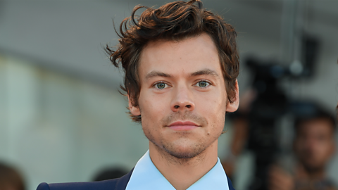 Harry Styles smiling while at an event.